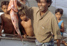 ampenan een trotse visser met zijn vangst  een grote Zeebaars